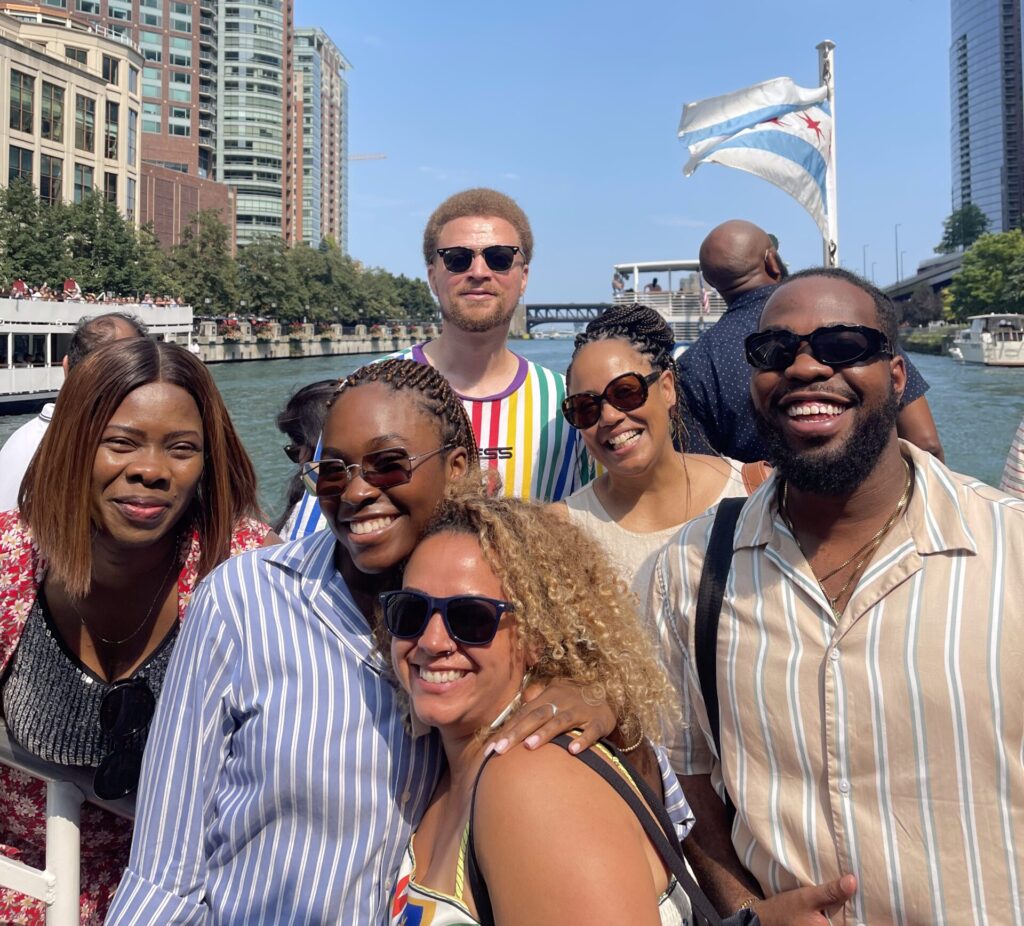 The image on the right side of the page consist of of the fellows in the fellowship program, outside on a bright sunny day. Each person is wearing summer clothes